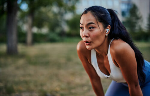 girl with her hands on her knees breathing heavily after an outdoor workout at Arista McKinney